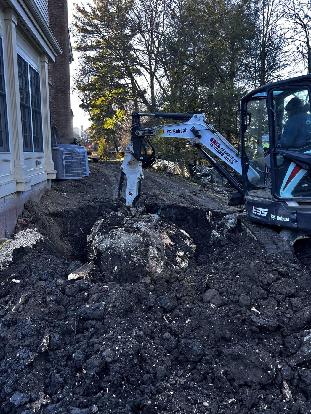 Mini excavator digging beside the house