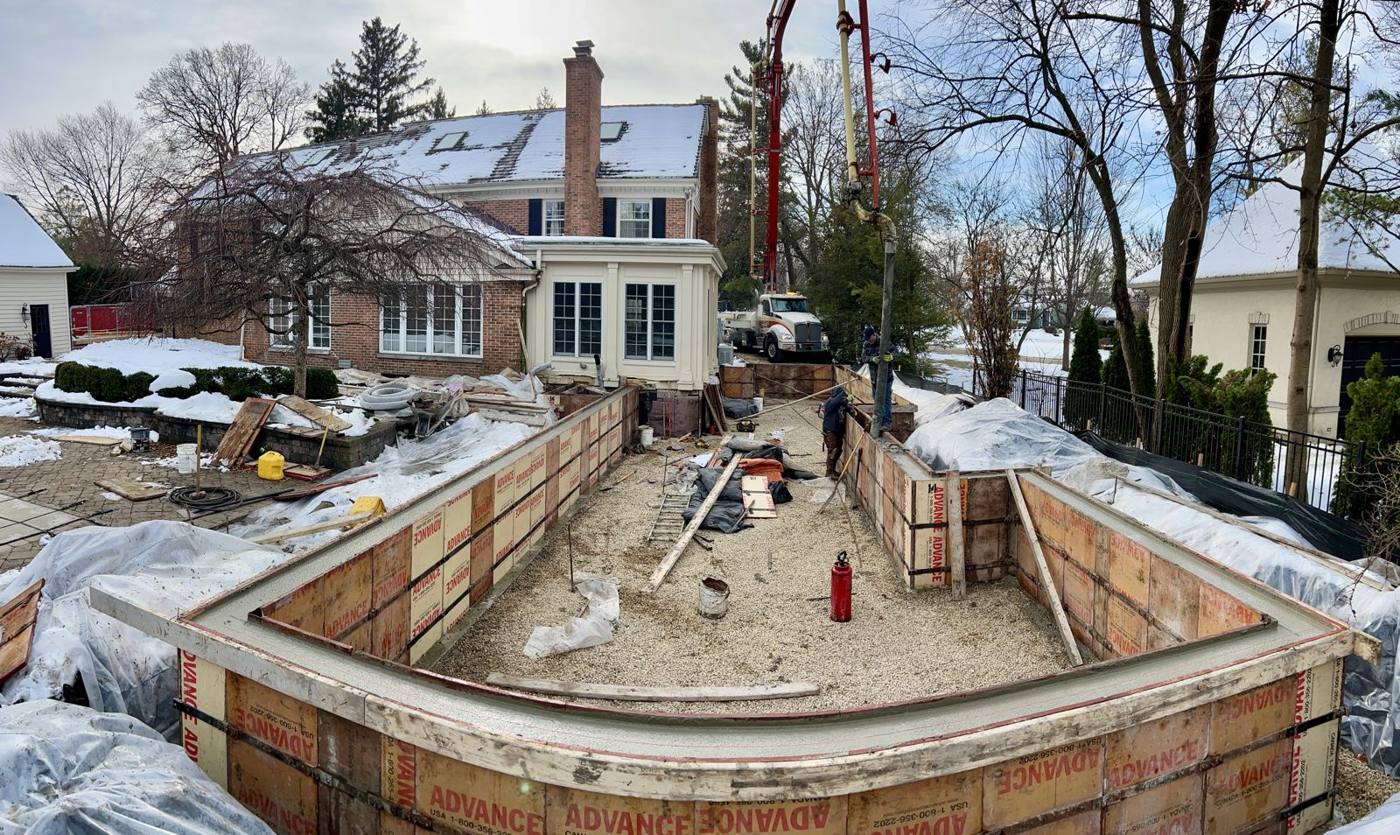 Wall forms full of concrete with the pump boom overhead