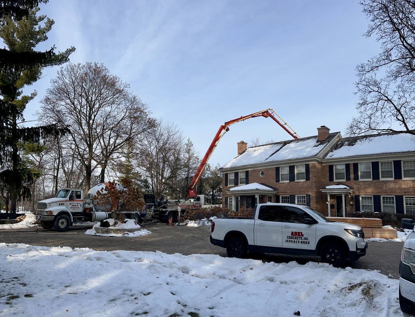 Concrete pump truck parked in the street in front of the house